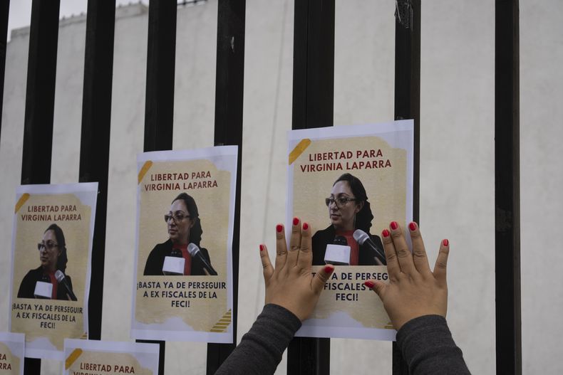 ARCHIVA - Una mujer coloca panfletos de apoyo a la fiscal guatemalteca Virginia Laparra, en Ciudad de Guatemala el 7 de junio de 2022. El Grupo de Trabajo sobre la Detención Arbitraria de las Naciones Unidas determinó que el encarcelamiento de Laparra es contrario al derecho internacional y pide su liberación, informaron sus abogados defensores el martes 13 de junio de 2023. Laparra fue sentenciada a cuatro años de cárcel por denunciar a un juez por haber filtrado información confidencial de un caso. (AP Foto/Moisés Castillo, Archivo)