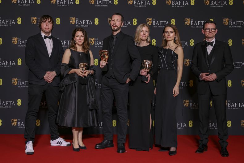 El fotógrafo de The Associated Press Evgeniy Maloletka, de izquierda a derecha, la editora y productora de Frontline de PBS Raney Aronson, el director, productor y periodista de AP Mstyslav Chernov, la editora y productora Michelle Mizner, la productora de campo y videoperiodista de AP Vasilisa Stepanenko, y el productor y vicepresidente de AP y director de producción Derl McCrudden, ganadores del premio a mejor documental por 20 Days in Mariupol, posan en la 77a entrega de los Premios de la Academia Británica de Cine (BAFTA) en Londres el domingo 18 de febrero de 2024. (Foto Vianney Le Caer/Invision/AP)