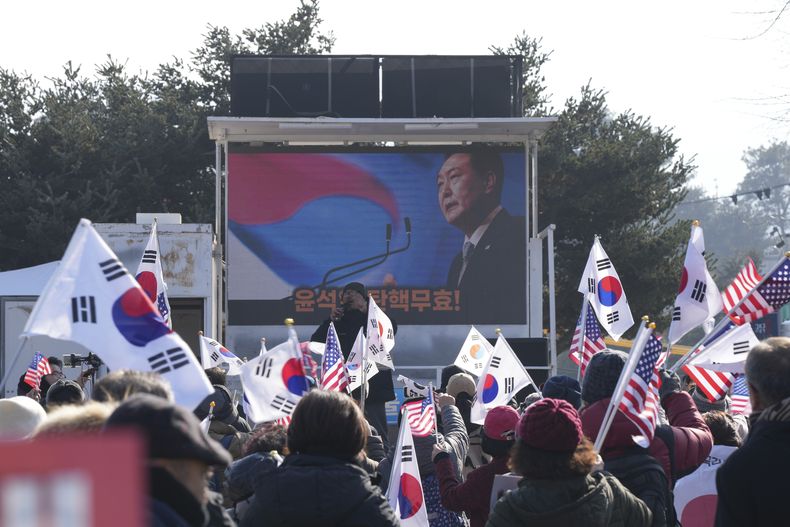 Una foto del presidente de Corea del Sur, Yoon Suk Yeol, quien enfrenta un proceso de juicio político, en una pantalla durante un mitin contra su suspensión, en el exterior de un centro de detención en Uiwang, Corea del Sur, el 17 de enero de 2025. (AP Foto/Lee Jin-man)