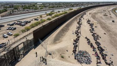 ARCHIVO - Migrantes forman filas frente a la valla en la frontera de Estados Unidos con México a la espera de ser transportados a una instalación de la Patrulla Fronteriza, el 10 de mayo de 2023, en El Paso, Texas. (AP Foto/Andrés Leighton, Archivo)