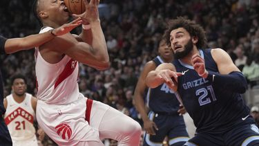 Scottie Barnes, izquierda, de los Raptors de Toronto, intenta pasar sobre David Roddy (21), de los Grizzlies de Memphis, durante la segunda mitad del juego de baloncesto de la NBA en Toronto, el lunes 22 de enero de 2024. (Nathan Denette/The Canadian Press vía AP)