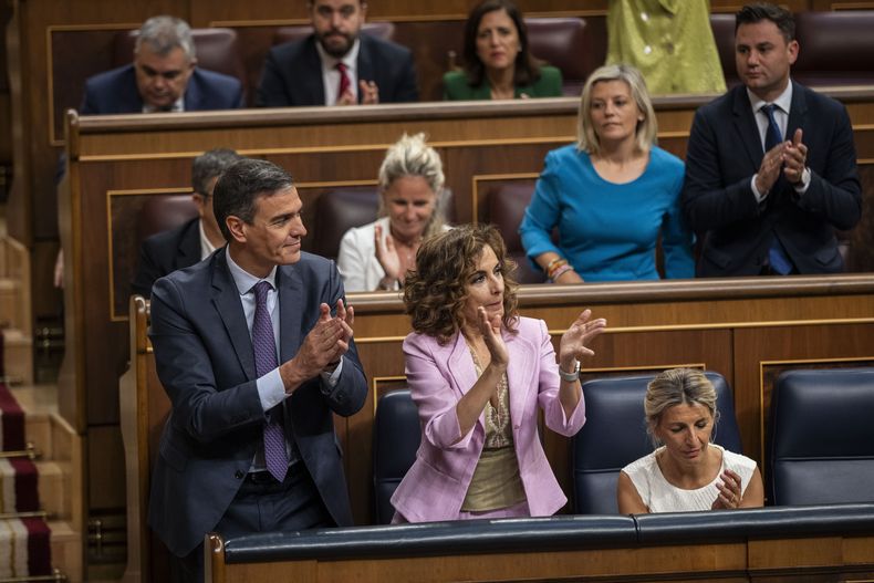 De izquierda a derecha, el presidente del gobierno de España, Pedro Sánchez; la vicepresidenta primera y ministra de Finanzas, María Jesús Montero, y la vicepresidenta segunda y ministra de Trabajo, Yolanda Díaz, aplauden tras la aprobación de una ley de amnistía en el Congreso de los Diputados, en Madrid, el 30 de mayo de 2024. (AP Foto/Bernat Armangue)