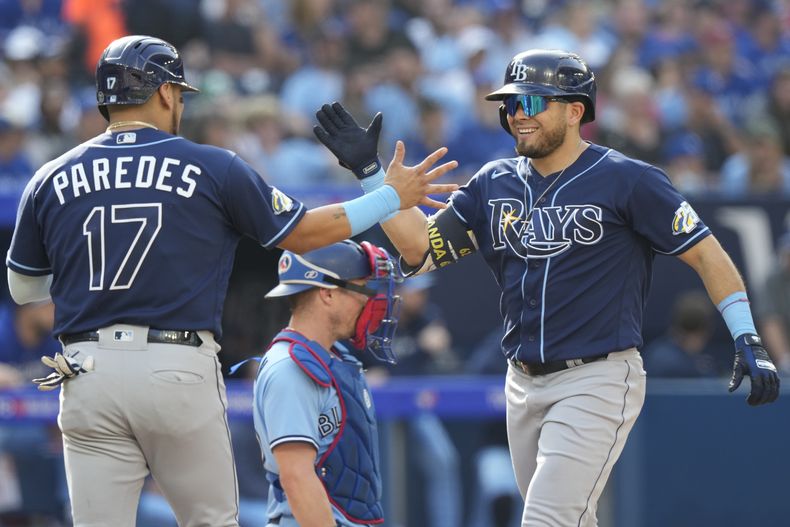 Jonathan Aranda, derecha, de los Rays de Tampa Bay, celebra con su compañero Isaac Paredes (17) después de batear un grand slam durante la segunda entrada del juego de béisbol en contra de los Azulejos de Toronto, el domingo 1 de octubre de 2023. (Frank Gunn/The Canadian Press vía AP)