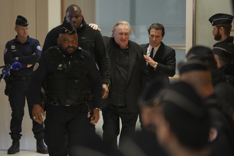 El actor Gerard Depardieu, en el centro, sale con su abogado Jeremie Assous, a la derecha, hacia la sala del tribunal para un receso durante su juicio por las presuntas agresiones sexuales a dos mujeres en una película de 2021, el martes 25 de marzo de 2025 en París. (Foto AP/Aurelien Morissard)