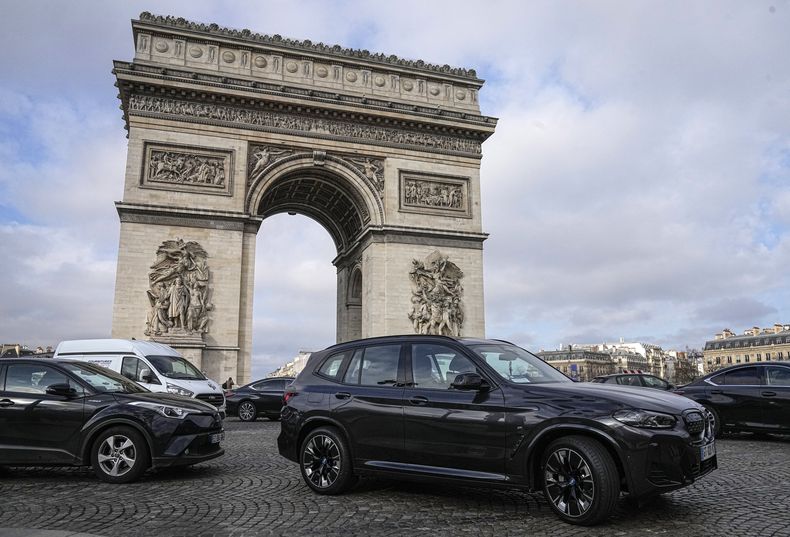 ARCHIVO - Algunas camionetas SUV circulan en los Campos Elíseos frente al Arco del Triunfo, el miércoles 31 de enero de 2024, en París. (AP Foto/Michel Euler, Archivo)