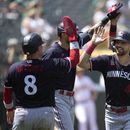 El puertorriqueño Christian Vazquez felicita a Edouard Julien y Max Kepler después de que ambos anotaron con un doble de Alex Kirilloff en la séptima entrada del juego ante los Atléticos de Oakland el domingo 16 de julio del 2023. (AP Foto/Jeff Chiu)