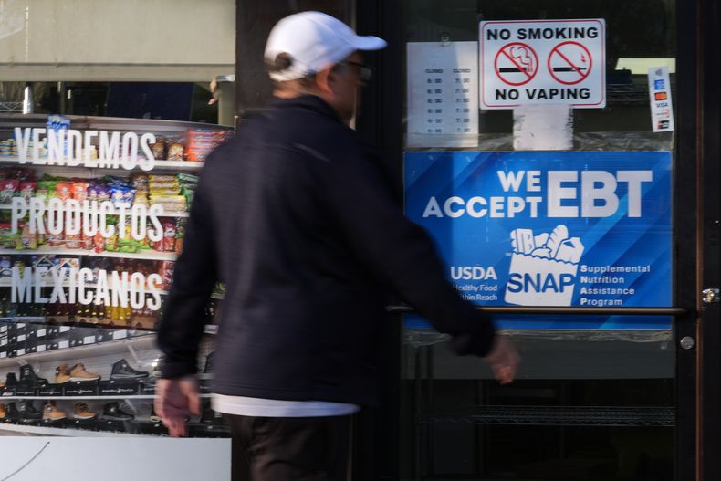 Un cliente pasa frente a una panadería con un letrero de información sobre el programa SNAP EBT, el domingo 2 de noviembre de 2025, en Chicago. (AP Foto/Nam Y. Huh)