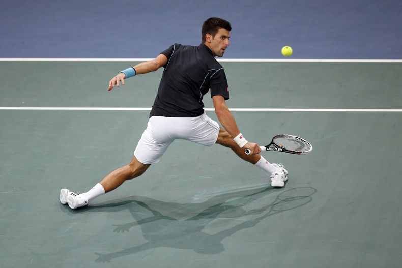 Novak Djokovic devuelve un disparo de Stanislas Wawrinka en el torneo Masters de Par&iacute;s el 1ro de enero del 2014. El serbio gan&oacute; en sets corridos y pas&oacute; a las semifinales. (AP Photo/Francois Mori)