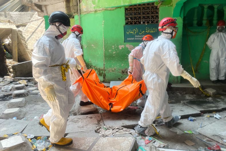 Rescatiscas trasladan el cuerpo de una víctima de un derrumbe en una escuela islámica en Sidoarjo, Java Oriental, Indonesia, el 3 de octubre de 2025. (AP Foto/Trisnadi)
