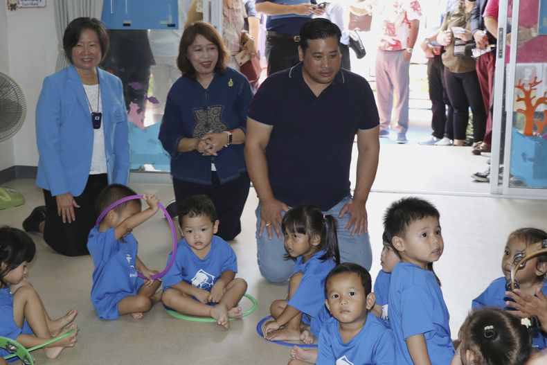 Vacharaesorn Vivacharawongse (centro a la der), hijo del rey de Tailandia, visita un centro de cuidados infantiles en Bangkok, el 8 de agosto de 2023. Foto proveida por la Fundación de Cuidados Infantiles para Barrios Pobres (Fundación de Cuidados Infantiles para Barrios Pobres via AP)