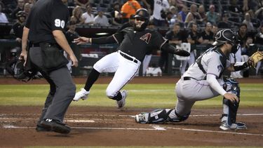 Emmanuel Rivera de los Diamondbacks de Arizona anota frente al cátcher de los Marlins de Miami Nick Fortes tras un doble de Christian Walker en la cuarta entrada del juego del lunes 8 de mayo del 2023. (AP Foto/Rick Scuteri)