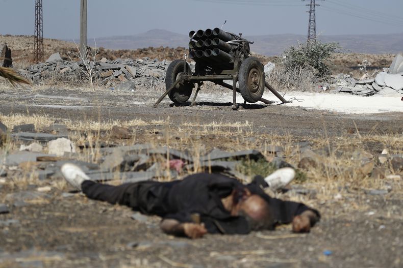 ARCHIVO - Un combatiente muerto de las milicias drusas yace en el suelo frente a un lanzacohetes en las afueras de la ciudad de Sweida, donde estallaron enfrentamientos entre clanes beduinos sunitas y milicias drusas, en el sur de Siria, el lunes 14 de julio de 2025. (AP Foto/Omar Sanadiki, archivo)