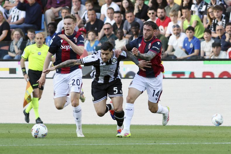 Martín Payero (centro) de Udinese pugna el balón con Davide Calabria (derecha) y Michel Aebischer de Bologna en la Serie A de Italia, el lunes 28 de abril de 2025. (Andrea Bressanutti/LaPresse vía AP)