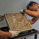 Restauradores exhiben un mosaico romano que representa a una pareja de amantes, que fue repatriado desde Alemania, en el parque arqueológico de Pompeya, Italia, el martes 15 de julio de 2025. (Foto AP/Gregorio Borgia)