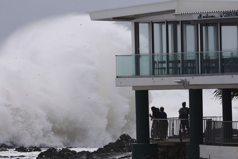 Gente mirando mientras enormes olas golpean las playas en Gold Coast, Australia, el jueves 6 de marzo de 2025. (Jason OBrien/AAP Image via AP)