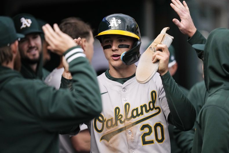 Zack Gelof, de los Atléticos de Oakland, es felicitado en la caseta del equipo después de anotar durante la novena entrada del juego de béisbol en contra de los Tigres de Detroit, el domingo 7 de abril de 2024, en Detroit. (AP Foto/Carlos Osorio)