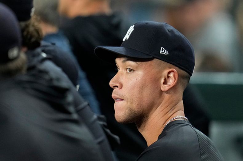 El jardinero lesionado de los Yankees de Nueva York, Aaron Judge, permanece sentado con sus compañeros en la caseta durante la sexta entrada de un partido de béisbol contra los Diamondbacks de Arizona, el 18 de septiembre de 2026, en Phoenix. (Foto AP/Ross D. Franklin)
