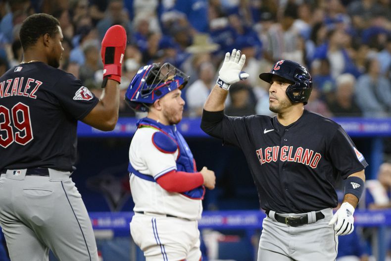 El dominicano Ramón Laureano festeja su jonrón de dos carreras por los Guardianes de Cleveland con su compatriota Óscar González, en el duelo del viernes 25 de agosto de 2023, ante los Azulejos de Toronto (Christopher Katsarov/The Canadian Press via AP)