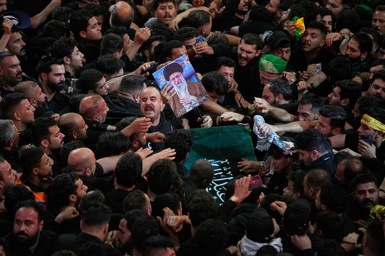 El ataúd del fallecido líder supremo de Irán, el ayatolá Alí Jamenei, es trasladado por una multitud mientras los dolientes tratan de tocarlo ante el santuario imán Hussein en Karbala, Irak, la madrugada del jueves 9 de julio de 2026. (AP Foto/Khalil Hamra)