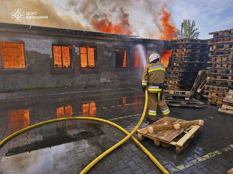 En esta imagen proporcionada por el Servicio Ucraniano de Emergencia, un bombero apaga el incendio tras un ataque ruso en la región de Kiev, Ucrania, el miércoles 9 de julio de 2025. (Servicio Ucraniano de Emergencia via AP)