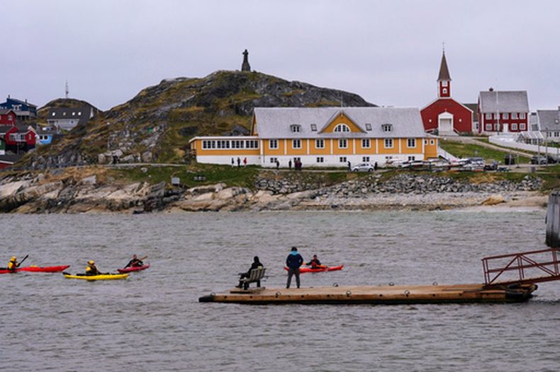 ARCHIVO - Turistas reman en kayak en el mar ante la catedral de Nuuk, en Nuuk, Groenlandia, el 16 de junio de 2025. (AP Foto/Kwiyeon Ha, Archivo)