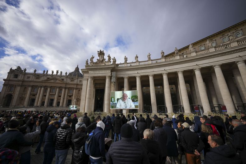 Fieles observan en una pantalla gigante el mensaje del papa Francisco, en la Plaza San Pedro, en el Vaticano, el domingo 22 de diciembre de 2024. (AP Foto/Andrew Medichini)