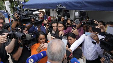 Periodistas conversan con el diputado panameño Luis Eduardo Camacho frente a la embajada de Nicaragua, donde el expresidente panameño Ricardo Martinelli ha permanecido refugiado durante más de un año para evitar su arresto en la Ciudad de Panamá, el lunes 31 de marzo de 2025. (Foto AP/Matías Delacroix)