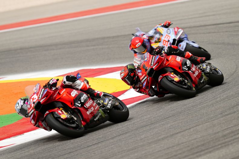 Enea Bastianini (izquierda) toma una curva, seguido por Francesco Bagnaia y Marc Márquez durante el Gran Premio de Portugal de MotoGP en Portimao, el 24 de marzo de 2024. (AP Foto/José Bretón)