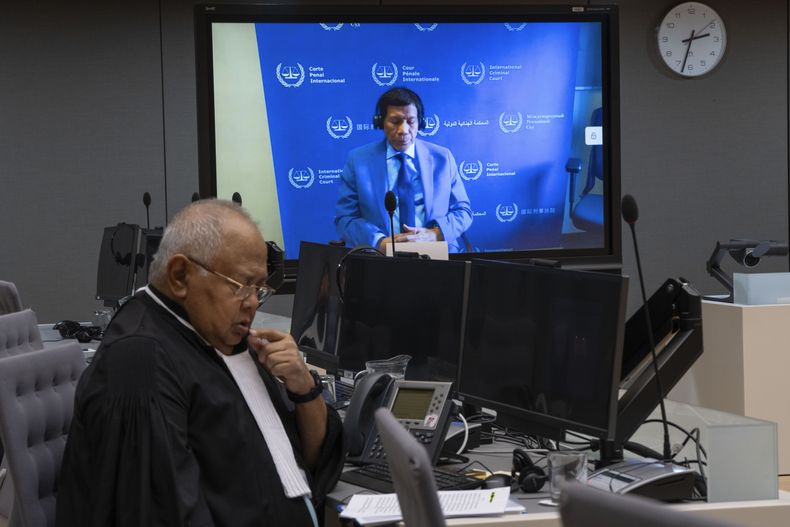El expresidente de Filipinas. Rodrigo Duterte, en una pantalla de la sala del tribunal de la Corte Penal Internacional (CPI) con su abogado Salvador Medialdea a la izquierda, en La Haya, Holanda, el viernes 14 de marzo de 2025. (AP Foto/Peter Dejong, Pool)