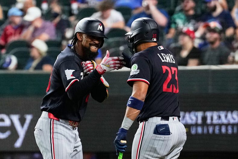 Byron Buxton, izquierda, y Royce Lewis (23), de los Mellizos de Minnesota, celebran el cuadrangjular solitario de Buxton en la sexta entrada del juego de béisbol de Grandes Ligas ante los Rangers de Texas, el lunes 15 de junio de 2026, en Arlington, Texas. (AP Foto/Tony Gutierrez)