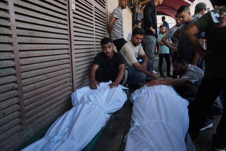 Palestinos asisten al funeral de dos personas fallecidas en un ataque del ejército israelí, en el exterior del hospital Mártires de Al-Aqsa, en Deir al-Balah, en el centro de la Franja de Gaza, el 4 de octubre de 2025. (AP Foto/Abdel Kareem Hana)
