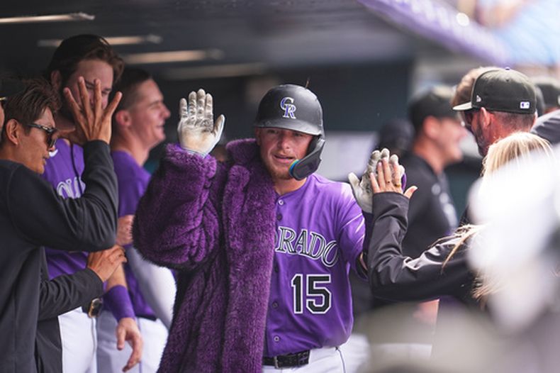 Hunter Goodman, de los Rockies de Colorado, se pone el abrigo de los jonrones, tras conseguir uno ante los Astros de Houston, el miércoles 8 de abril de 2026 (AP Foto/David Zalubowski)