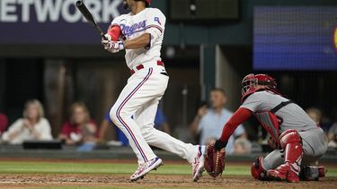 Marcus Semien, de los Rangers de Texas, conecta un doblete delante del cátcher venezolano Willson Contreras, de los Cardenales de San Luis, el martes 6 de junio de 2023 (AP Foto/Tony Gutiérrez)