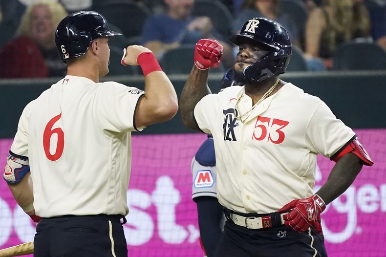 El cubano Adolis García (53) festeja con su compañero Josh Jung, luego de batear un jonrón en el duelo del viernes 14 de julio de 2023, ante los Guardianes de Cleveland (AP Foto/LM Otero)