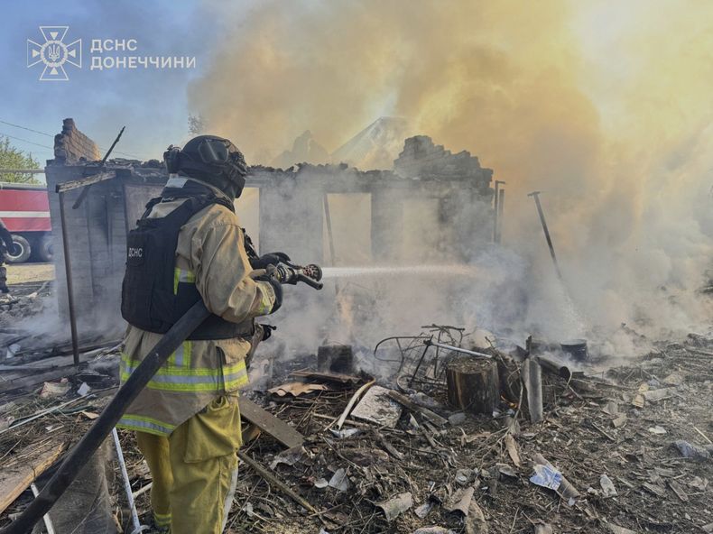 En esta imagen proporcionada por el Servicio de Emergencias de Ucrania, un bombero combate un incendio en viviendas en ruinas tras un ataque ruso en la región de Donetsk, Ucrania, el lunes 28 de abril de 2025. (Servicio de Emergencias de Ucrania vía AP)