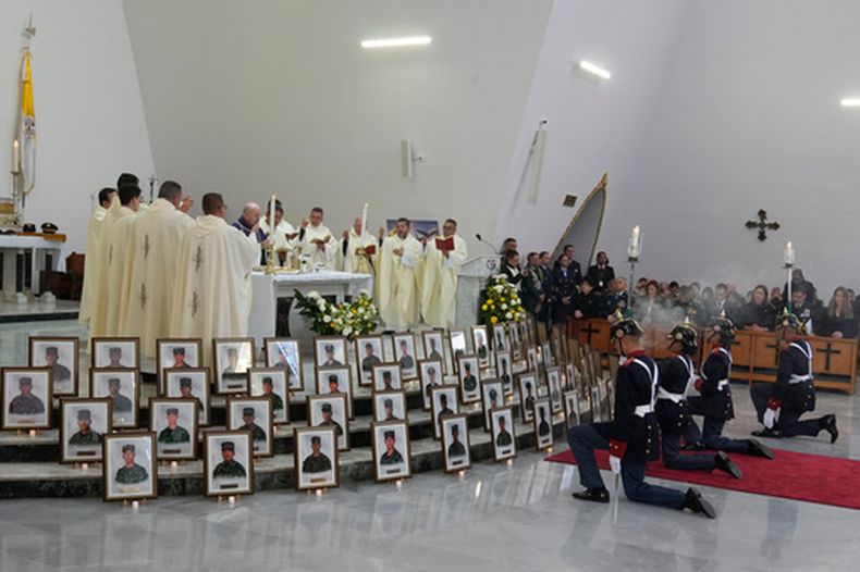 El obispo militar monseñor Víctor Manuel Ochoa celebra una misa en honor a las víctimas de un avión de carga militar que se estrelló en Puerto Leguizamo, cuyas fotografías están expuestas, en la iglesia de la base militar Cantón Norte en Bogotá, Colombia, el viernes 27 de marzo de 2026. (AP Foto/Fernando Vergara)