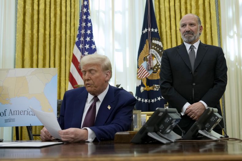 El secretario de Comercio Howard Lutnick escucha mientras el presidente Donald Trump habla después de firmar una orden ejecutiva en la Oficina Oval en la Casa Blanca en Washington el 13 de febrero del 2025. (AP foto/Ben Curtis)