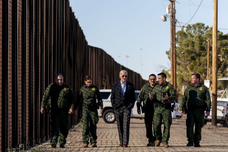 ARCHIVO - El presidente estadounidense Joe Biden camina junto con agentes de la Patrulla Fronteriza en un tramo de la frontera entre Estados Unidos y México, el domingo 8 de enero de 2023, en El Paso, Texas. (AP Foto/Andrew Harnik, archivo)