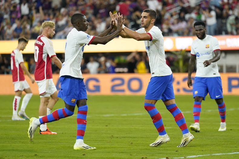 Ferran Torres (centro) celebra tras anotar un gol para el Barcelona junto a su compañero Ousmane Dembélé en el amistoso contra Arsenal, el miércoles 26 de julio de 2023, en Inglewood, California. (AP Foto/Ashley Landis)
