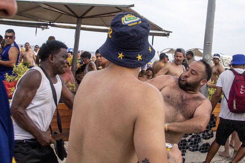 Un fanático de Boca Juniors, de Argentina, derecha, y uno de Fluminense, de Brasil, pelean en la playa de Copacabana un día antes del partido entre sus equipos por la Final de la Copa Libertadores, en Río de Janeiro, Brasil, el viernes 3 de noviembre de 2023. (AP Foto/Bruno Kaiuka)
