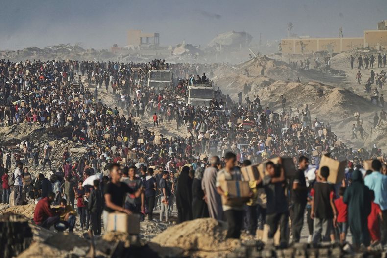 ARCHIVO - Palestinos cargan sacos y cajas de alimentos y ayuda humanitaria, descargados de un convoy del Programa Mundial de Alimentos que se dirigía a Ciudad de Gaza, el lunes 16 de junio de 2025, en el norte de la Franja de Gaza. (AP Foto/Jehad Alshrafi, archivo)