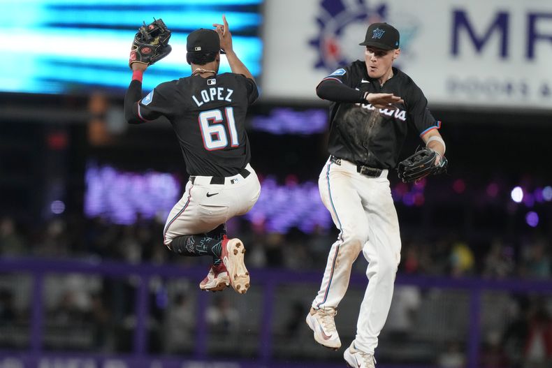 Otto Lopez (61), segunda base de los Marlins de Miami, y el jardinero central Kyle Stowers celebran al final del partido de béisbol en contra de los Bravos de Atlanta, el viernes 20 de septiembre de 2024, en Miami. (AP Foto/Marta Lavandier)