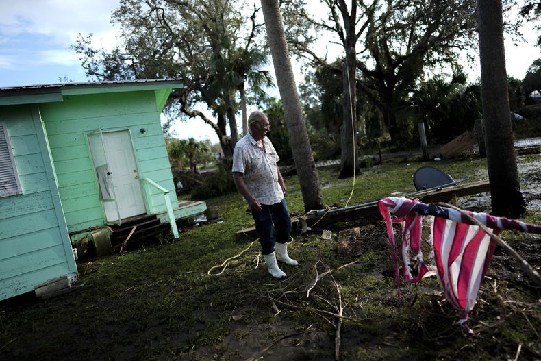 Una bandera estadounidense destrozada, enrollada en su asta en el jardín delantero de Herman Neely, un funcionario de prisiones retirado, luego de que la marejada ciclónica causada por Idalia causó daños a su vivienda, en Horseshoe Beach, Florida, el 31 de agosto de 2023, un día después del paso del huracán. (AP Foto/Rebecca Blackwell)