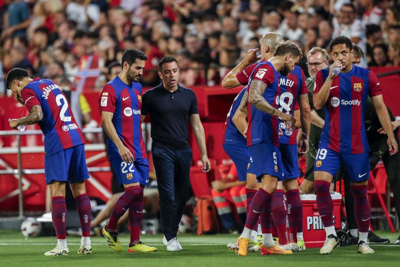 Xavi Hernandez, entrenador del Barcelona, platica con sus jugadores durante el partido de fútbol de La Liga de España entra Sevilla y FC Barcelona en el estadio Ramón Sánchez Pizjuan, en Sevilla, España, el domingo 26 de mayo de 2024. (AP Foto/Fermin Rodriguez)