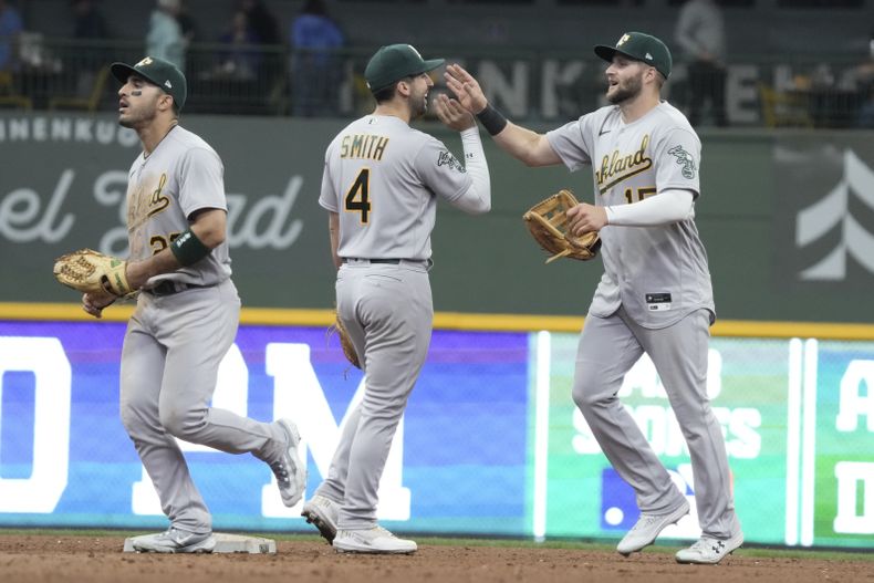 Ramon Laureano, Kevin Smith y Seth Brown, de los Atléticos de Oakland, celebran después de derrotar a los Cerveceros de Milwaukee el juego de béisbol el domingo 11 de junio de 2023, en Milwaukee. Los Atléticos ganaron 8-6 y barrieron la serie. (AP Foto/Morry Gash)