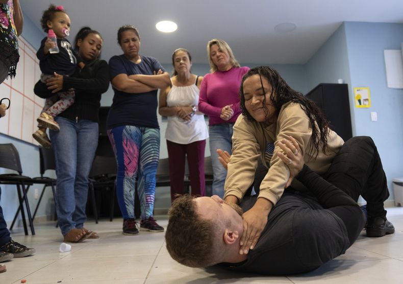 Nadia recibe instrucciones de Roberto Camara el jueves 20 de julio de 2023, durante una clase de defensa personal dirigida a mujeres que han sufrido violencia doméstica en Río de Janeiro, Brasil. (AP Foto/Silvia Izquierdo)