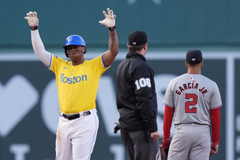 El dominicano Rafael Devers, de los Medias Rojas de Boston, festeja su doble de dos carreras junto a Luis García, de los Nacionales de Washington, el sábado 11 de mayo de 2024 (AP Foto/Michael Dwyer)