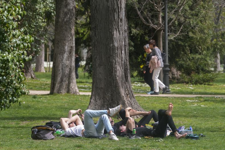 ARCHIVO - Varias personas descansan en el parque del Retiro el miércoles 20 de marzo de 2024, en Madrid, España. (AP Foto/Paul White, archivo)