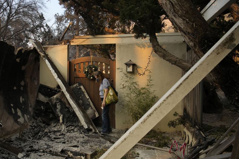 Glenda, que rechazó dar su apellido, de pie cerca de la entrada de su casa destruida por el incendio Eaton, el jueves 9 de enero de 2025, en Altadena, California. (AP Foto/John Locher)