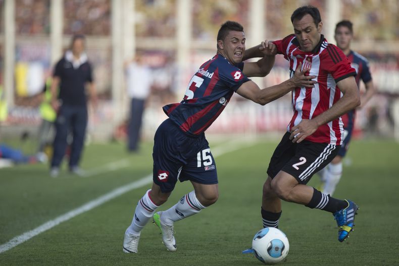 H&eacute;ctor Villalba (izquierda) del San Lorenzo lucha por el bal&oacute;n con Leandro Desabato de Estudiantes de la Plata durante el juego del domingo 1 de diciembre de 2013 del torneo Inicial en Argentina. (Foto de AP/Eduardo Di Baia)